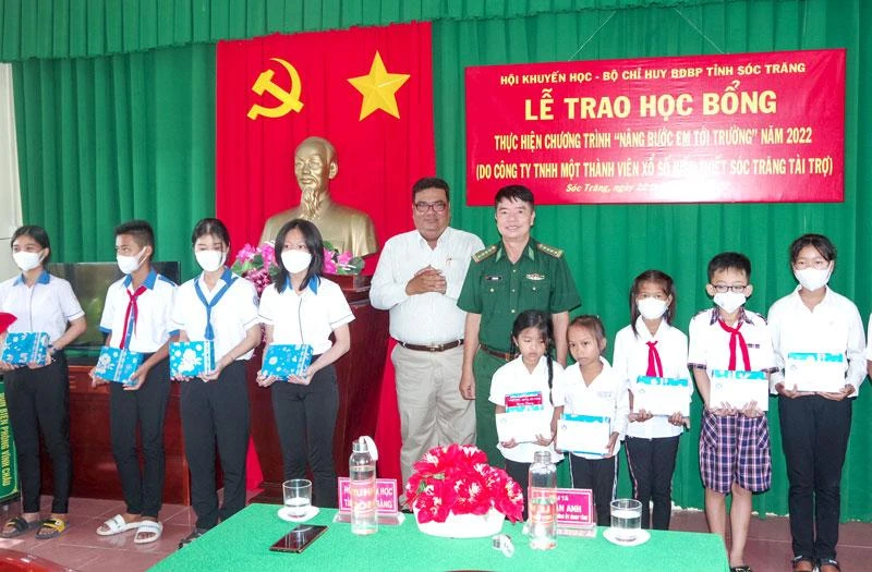 Đại diện Bộ đội Biên phòng tỉnh và Hội khuyến học tỉnh Sóc Trăng trao học bổng cho các em học sinh. (Ảnh: VĂN LONG)