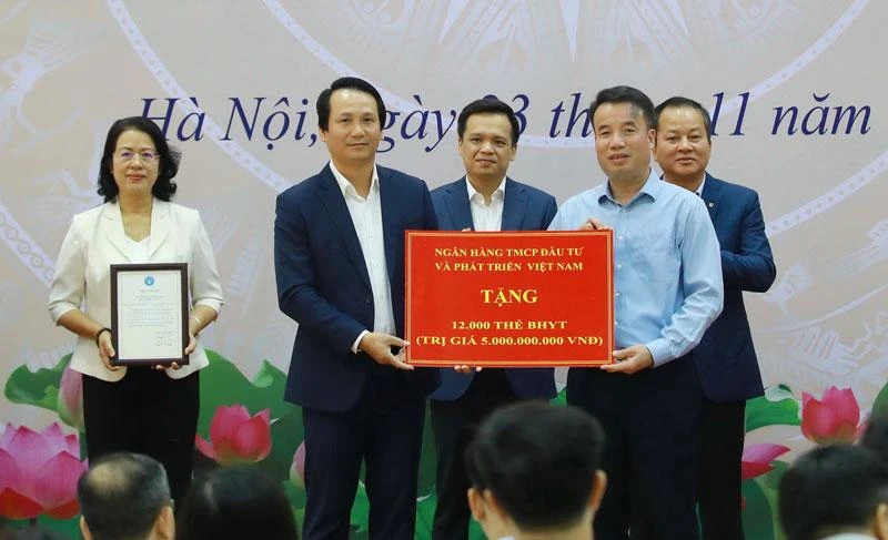 Ông Trần Long, Phó Tổng giám đốc BIDV (bên trái) đại diện ngân hàng trao tặng 12.000 thẻ BHYT trị giá 5 tỷ đồng.
