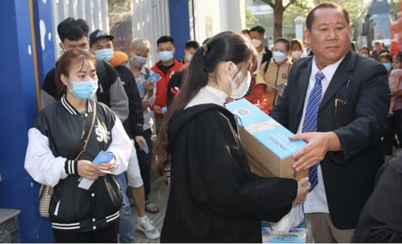 Các sinh viên, người lao động nhận quà Tết trước khi lên xe về quê vào ngày 25 tháng Chạp.