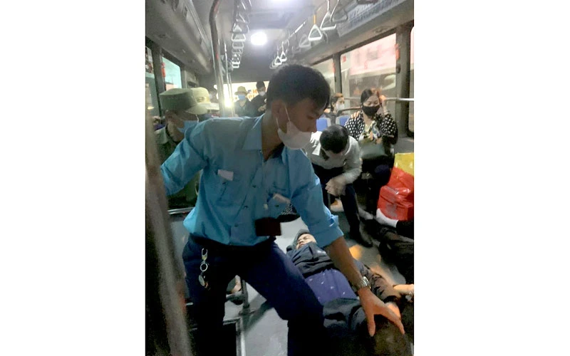 Nhân viên xe buýt đưa người bị thương lên xe để chở đến bệnh viện cấp cứu.