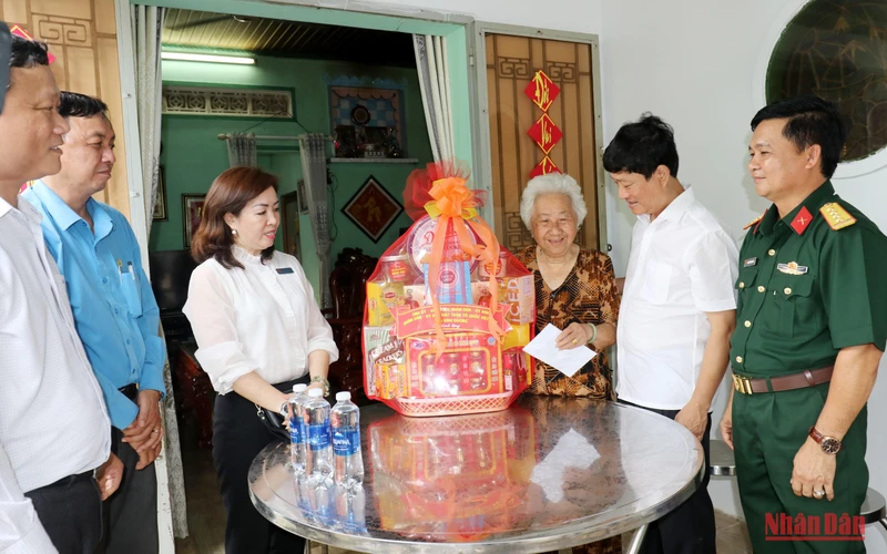 Đồng chí Võ Văn Minh, Phó Bí thư Tỉnh ủy, Chủ tịch UBND tỉnh Bình Dương (thứ hai, bên phải) thăm hỏi, tặng quà cho bà Nguyễn Thị Kiểu, mẹ liệt sĩ.