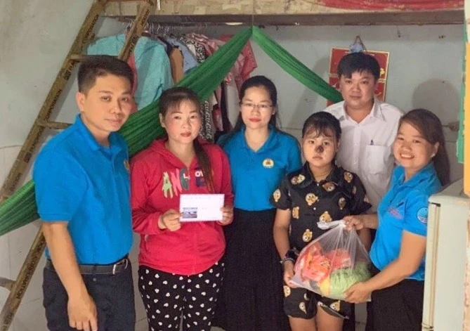 Cán bộ công đoàn tặng quà con công nhân có hoàn cảnh khó khăn tại khu trọ phường An Bình (thành phố Dĩ An, Bình Dương). (Ảnh: HUYỀN TRANG) 