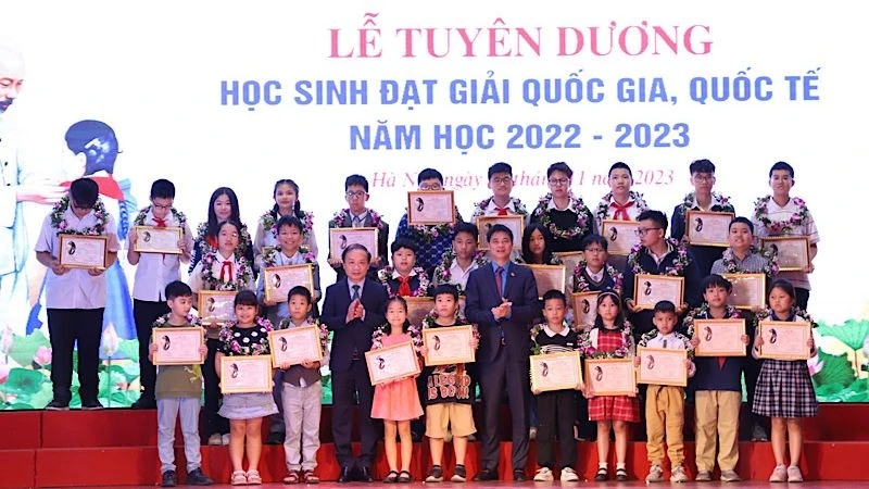Đồng chí Phạm Tất Thắng và đồng chí Ngọ Duy Hiểu trao khen thưởng cho các em học sinh.