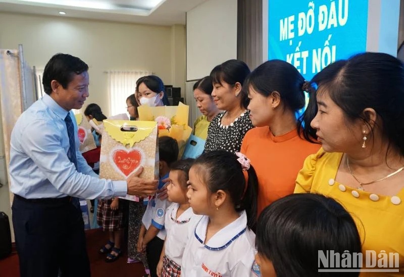 Lãnh đạo Ủy ban nhân dân tỉnh Long An trao hoa cho các mẹ đỡ đầu và quà cho trẻ mồ côi. 