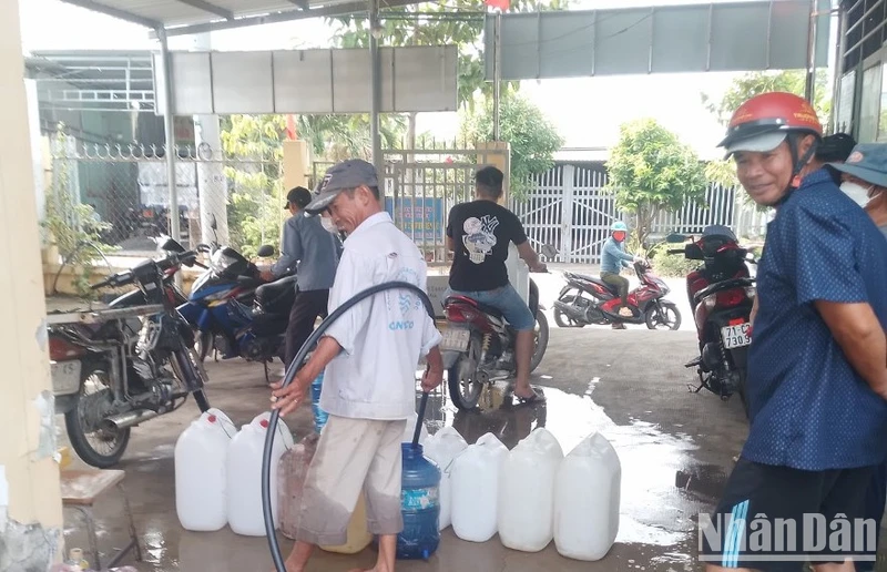 Người dân xã Tân Tập (Cần Giuộc, Long An) lấy nước ngọt từ xe chờ nước của đơn vị cấp nước hỗ trợ bà con trong lúc thiếu nguồn nước ngọt hợp vệ sinh từ hệ thống cấp nước. 
