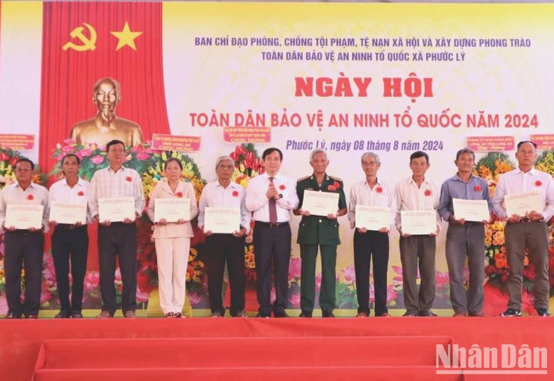 Phó Ban Tuyên giáo Trung Ương Phan Xuân Thủy tặng quà của Trung ương cho người có công, gia đình chính sách trên địa bàn xã Phước Lý, huyện Cần Giuộc, Long An.