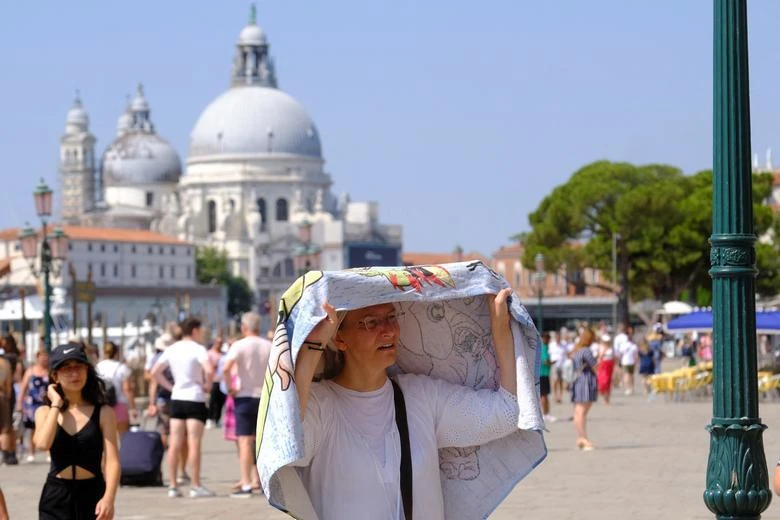 Du khách chống nóng ở Venice, Italia hôm 16/7 (Ảnh: REUTERS)
