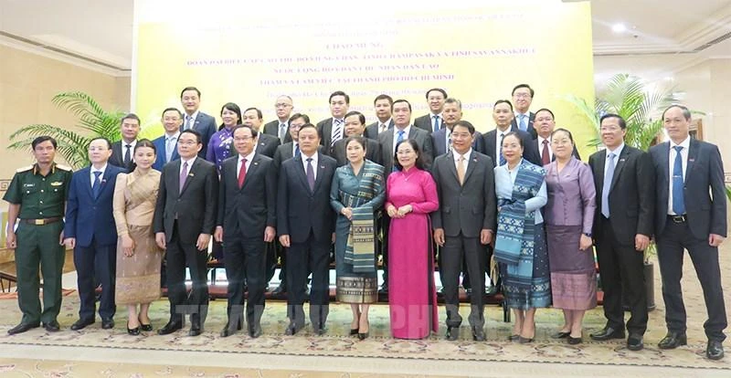 Đồng chí Nguyễn Văn Nên cùng các đại biểu Việt Nam - Lào chụp hình lưu niệm (Ảnh: https://thanhuytphcm.vn)