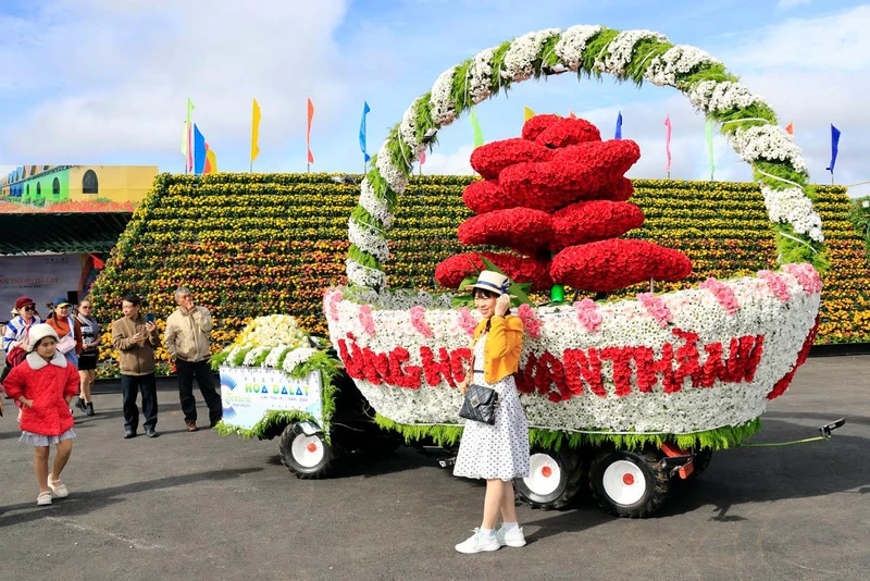 Du khách lưu dấu kỷ niệm bên xe hoa của Làng hoa Vạn Thành tham gia Festival Hoa Đà Lạt năm 2022.