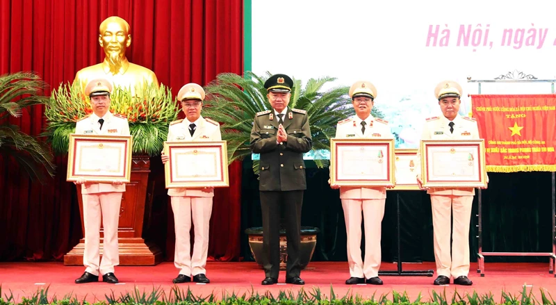 Bộ trưởng Công an Tô Lâm trao phần thưởng của Đảng Nhà nước cho cán bộ Công an thành phố có thành tích xuất sắc.