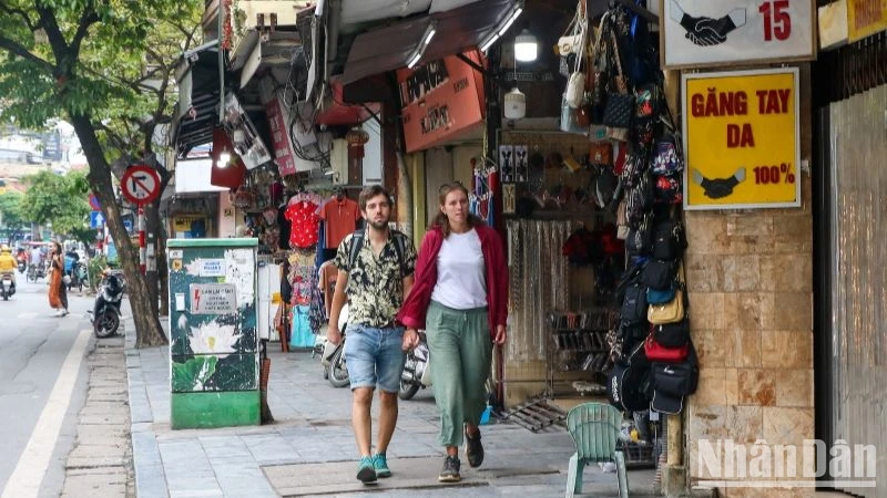 Du khách nước ngoài rảo bước trên phố Hàng Đào, Hà Nội. (Ảnh: NHẬT QUANG)