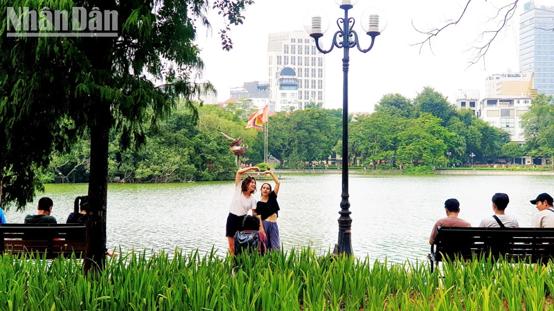 Du khách nước ngoài chụp ảnh tại Hồ Gươm, Hà Nội (Ảnh: T.LINH)