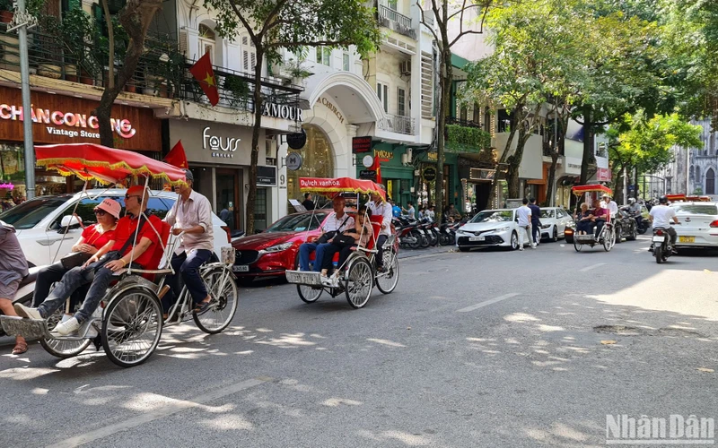 Khách du lịch nước ngoài tham quan phố cổ Hà Nội bằng xe xích lô. (Ảnh: T.LINH)
