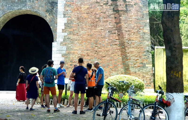 Khách du lịch nước ngoài theo tour tham quan Hà Nội bằng xe đạp tại thành Cửa Bắc trên phố Phan Đình Phùng. (Ảnh: T.LINH)