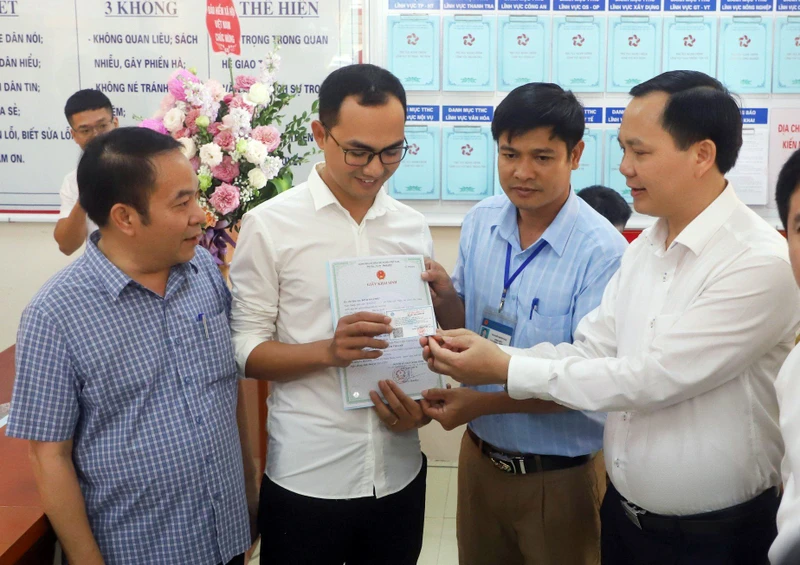 Đại diện Bảo hiểm xã hội Việt Nam trao thẻ bảo hiểm y tế của bé gái đầu tiên được cấp giấy khai sinh, thẻ bảo hiểm y tế đồng thời với đăng ký thường trú thông qua Dịch vụ công liên thông, thí điểm tại huyện Thanh Liêm (Hà Nam). 