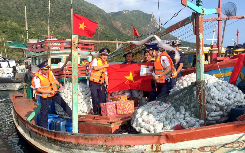 Cán bộ Bộ Tư lệnh Cảnh sát biển trao cờ Tổ quốc và quà tặng ngư dân tại cảng Bến Đầm, huyện Côn đảo, tỉnh Bà Rịa-Vũng Tàu.