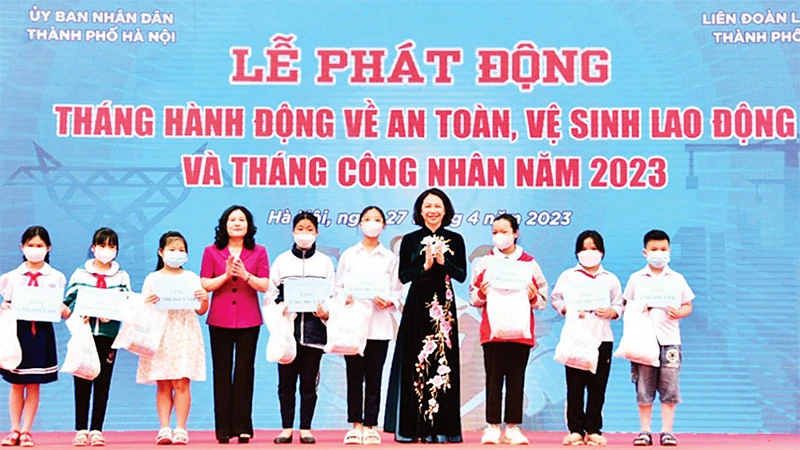 Lãnh đạo Bộ Lao động-Thương binh và Xã hội và UBND thành phố Hà Nội trao quà tặng con đoàn viên công đoàn có hoàn cảnh khó khăn, bị tai nạn lao động. (Ảnh TRẦN OANH)