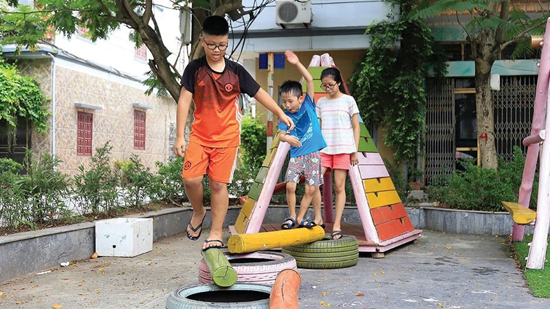 Trẻ em vui chơi tại sân chơi làm từ vật liệu tái chế do nhóm Think Playgrounds xây dựng trên địa bàn phường Việt Hưng, quận Long Biên, Hà Nội. (Ảnh Quang Thái)