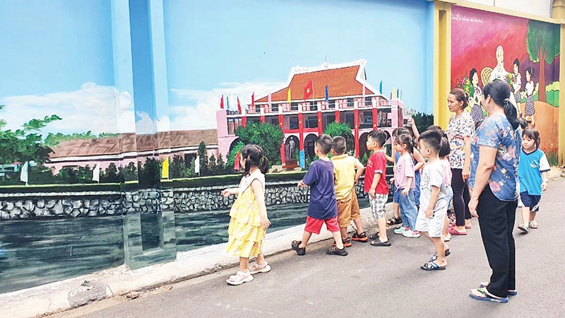 Thiếu nhi xem bức tranh Bến Nhà Rồng được vẽ trong một tuyến hẻm ở quận Phú Nhuận.