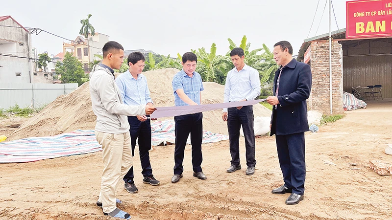 Cán bộ Trung tâm Phát triển quỹ đất huyện Mê Linh giới thiệu về quy hoạch chi tiết khu tái định cư Khê Ngoại 3, xã Văn Khê. (Ảnh HẢI CHI)