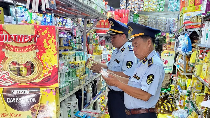 Cán bộ Cục Quản lý thị trường tỉnh Kiên Giang kiểm tra hàng hóa tại một cơ sở kinh doanh. (Ảnh MINH TRANG)