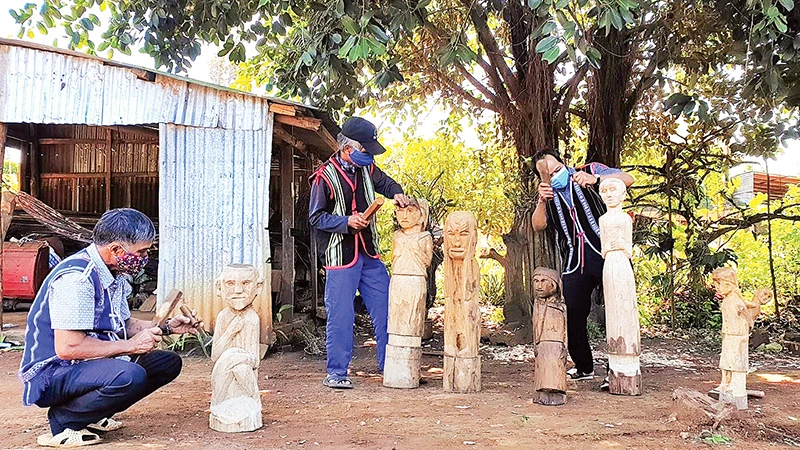 Các nghệ nhân ở xã Ia Ka, huyện Chư Păh (tỉnh Gia Lai) đang sáng tạo, chế tác tượng gỗ.