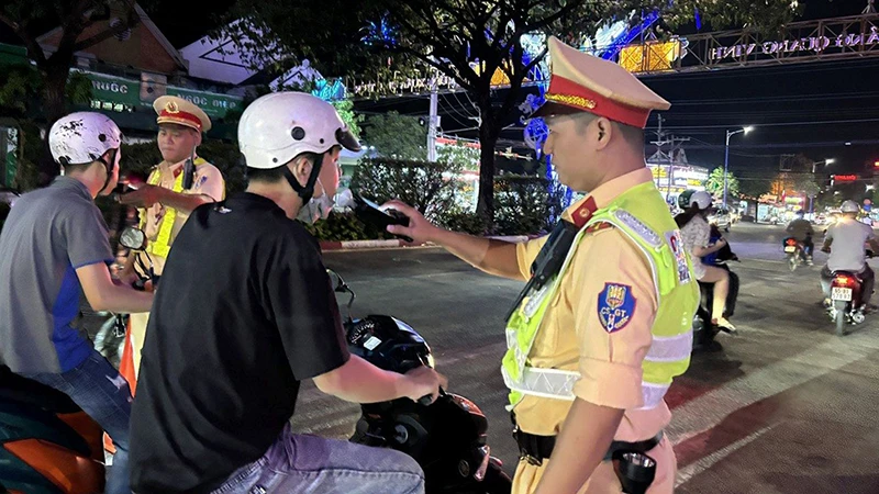 Lực lượng Cảnh sát giao thông thị xã Bến Cát, tỉnh Bình Dương kiểm tra nồng độ cồn của người điều khiển phương tiện tham gia giao thông. (Ảnh NGUYỄN PHỤNG)