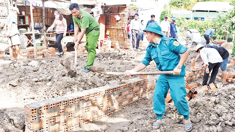 Lực lượng vũ trang cùng các đoàn thể chính trị xã Huyền Hội, huyện Càng Long hỗ trợ người dân xây nhà.