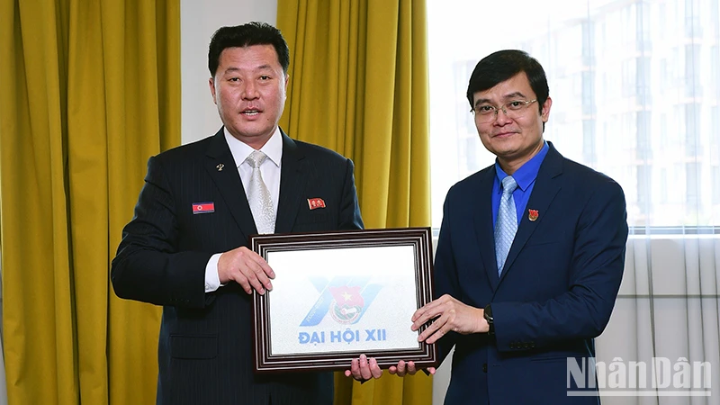 Đồng chí Bùi Quang Huy (phải) tặng quà lưu niệm đồng chí Mun Chol. (Ảnh: THANH THỂ)