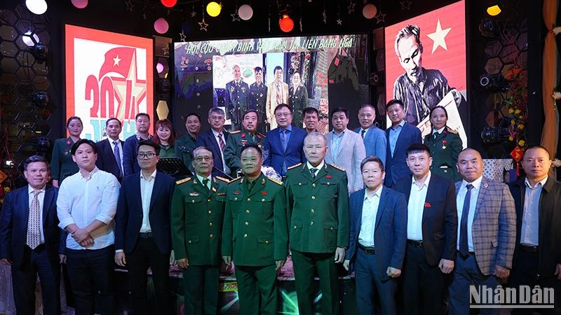 Các cựu chiến binh Việt Nam chụp ảnh lưu niệm với các đại biểu tham dự cuộc gặp. (Ảnh: XUÂN HƯNG)
