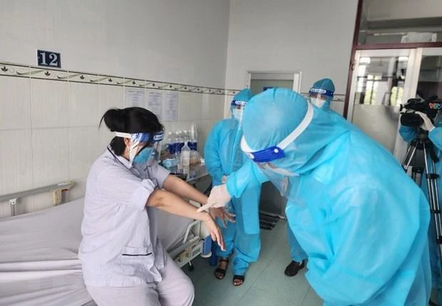 Lãnh đạo Cục Y tế dự phòng, Bộ Y tế thăm hỏi, động viên người bệnh mắc đậu mùa khỉ. (Ảnh: TTXVN)