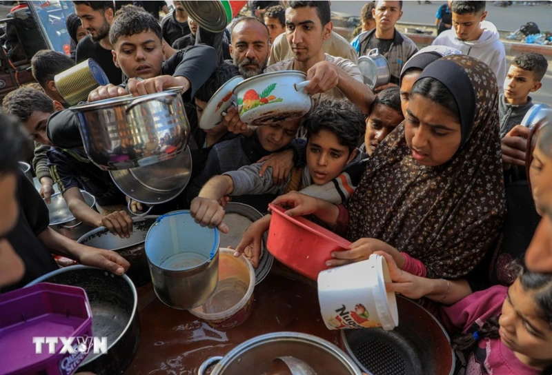 Người dân chờ nhận thức ăn cứu trợ tại thành phố Rafah, Dải Gaza, ngày 30/3/2024. Ảnh: THX/TTXVN.
