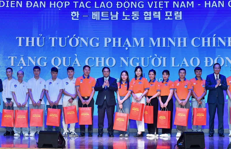 Thủ tướng Phạm Minh Chính tặng quà cho người lao động tiêu biểu Việt Nam tại Hàn Quốc.