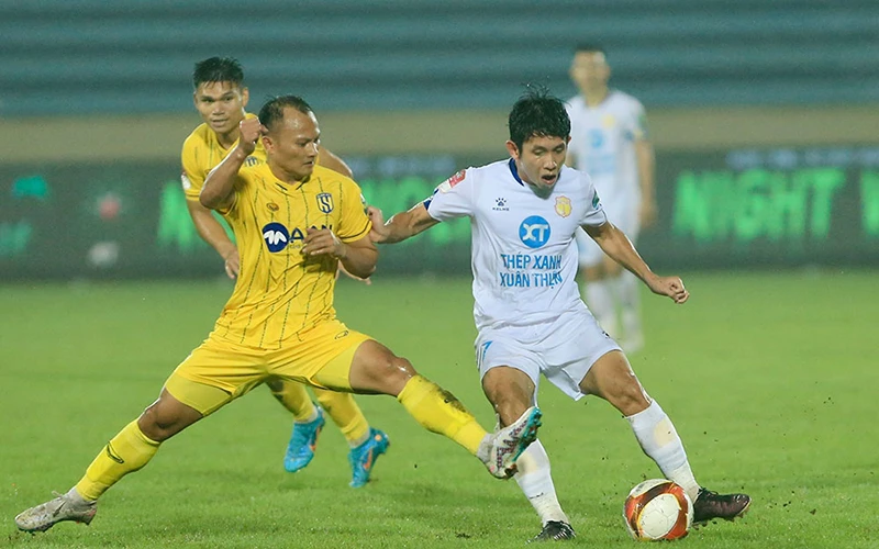 Pha tranh bóng giữa cầu thủ hai đội Thép Xanh Nam Định (áo trắng) và Sông Lam Nghệ An. (Ảnh VPF)