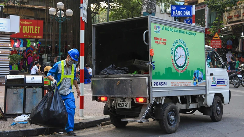 Công nhân Công ty Môi trường đô thị Hà Nội thu gom rác thải trên địa bàn quận Hoàn Kiếm. (Ảnh PHẠM HÙNG)