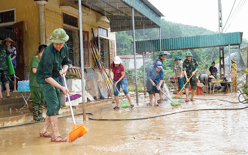 Lực lượng công an, bộ đội huyện Quỳ Châu (Nghệ An) giúp vệ sinh môi trường sau lũ tại điểm Trường mầm non Tà Sỏi, xã Châu Hạnh.