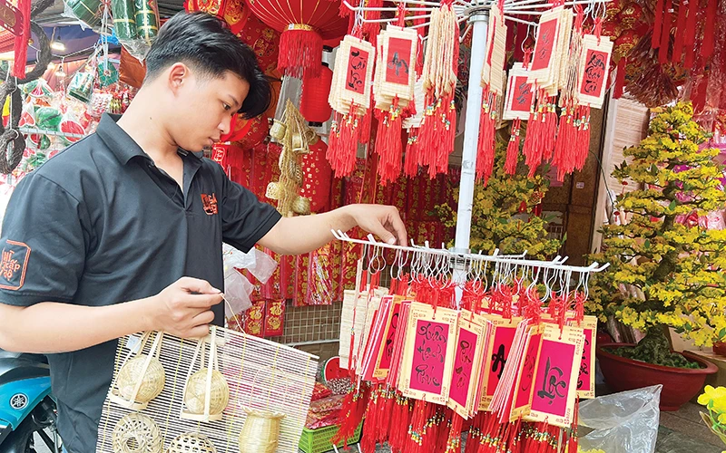 Khách hàng lựa chọn đồ trang trí Tết thuần Việt bày bán trên đường Hải Thượng Lãn Ông, Quận 5.