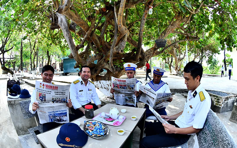 Các cán bộ, chiến sĩ hải quân trên đảo Sinh Tồn (huyện đảo Trường Sa, tỉnh Khánh Hòa) đón đọc các ấn phẩm của Báo Nhân Dân. (Ảnh ĐĂNG KHOA)