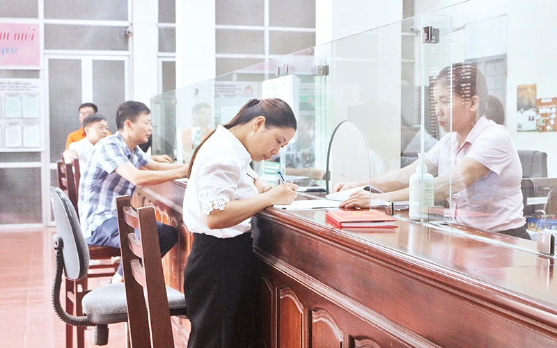 Nhân viên Ngân hàng Chính sách xã hội thị xã Duy Tiên giải ngân cho khách hàng vay để mua nhà ở xã hội.