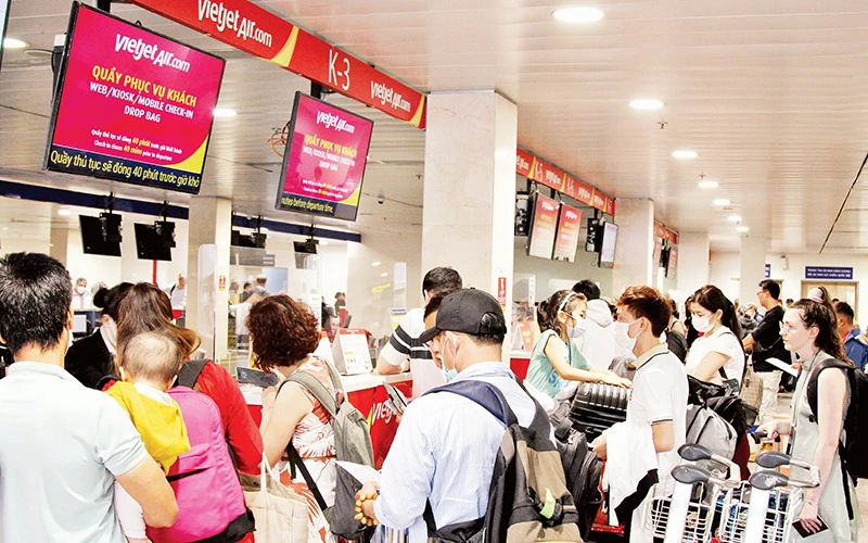 Người dân làm thủ tục tại Sân bay Tân Sơn Nhất. (Ảnh THẾ ANH)