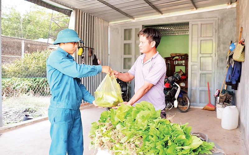 Dân quân xã biên giới Thanh Hòa (huyện Bù Đốp, tỉnh Bình Phước) tặng người dân rau xanh do đơn vị tăng gia.