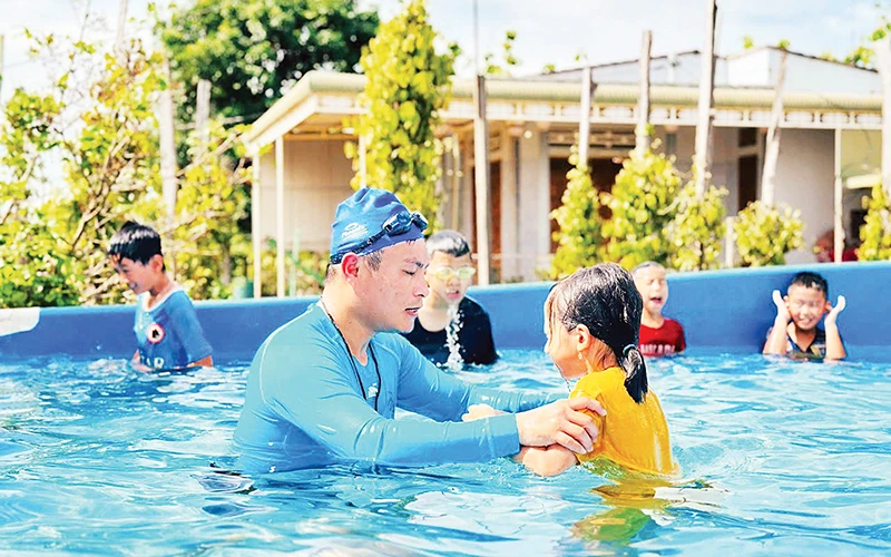 Thầy giáo Mai Văn Chuyền dạy bơi miễn phí cho các em học sinh ở thôn Hiệp Hưng, xã Quảng Hiệp, huyện Cư M’gar.