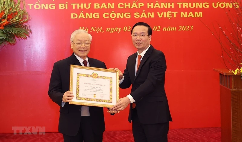 Đồng chí Võ Văn Thưởng, Ủy viên Bộ Chính trị, Thường trực Ban Bí thư trao Huy hiệu 55 năm tuổi Đảng tặng Tổng Bí thư Nguyễn Phú Trọng. (Ảnh: TTXVN)