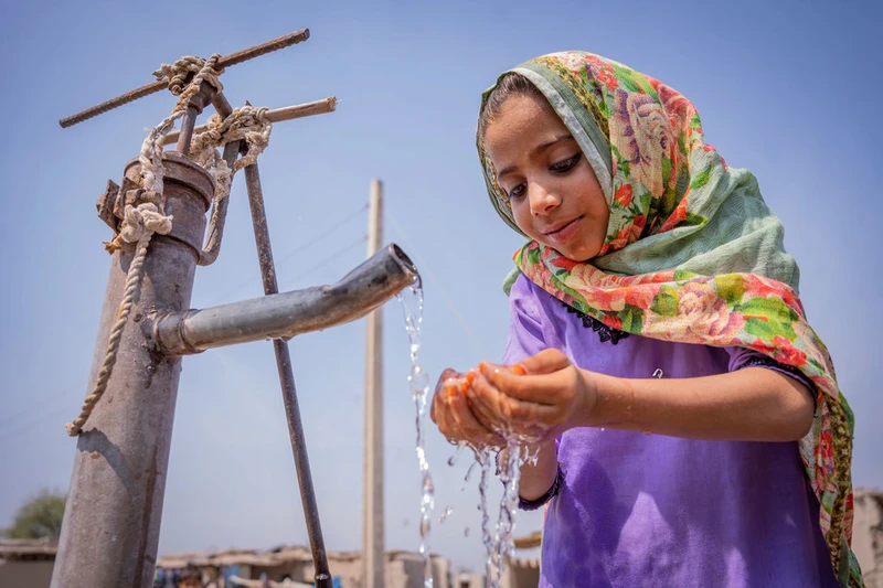 Một cô bé đang uống nước từ máy bơm tay tại Pakistan. Nguồn: UN