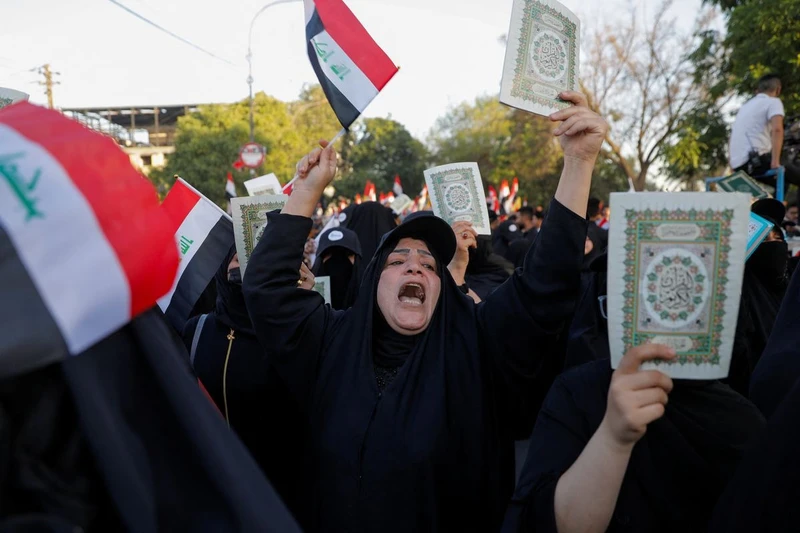 Những người biểu tình ở Iraq cầm cuốn kinh Koran trong một cuộc biểu tình phản đối các hành vi báng bổ kinh Koran. ngày 22/7/2023. Ảnh: REUTERS
