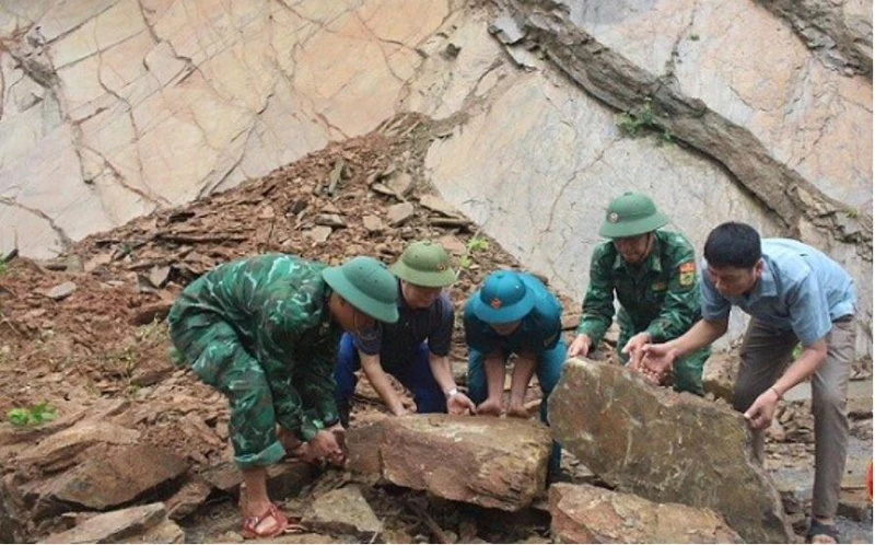 Cán bộ chiến sĩ Đồn Biên phòng Mường Ải phối hợp với các lực lượng và nhân dân khắc phục tình trạng đá sạt lở gây ách tắc giao thông, mất an toàn trên tuyến đường qua địa bàn.