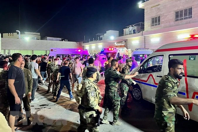 Binh sĩ và lực lượng phản ứng nhanh Iraq chuyển các nạn nhân vụ hỏa hoạn trong đám cưới tới bệnh viện Hamdaniyah ở Al-Hamdaniyah, Iraq ngày 27/9. (Ảnh: AFP/TTXVN)