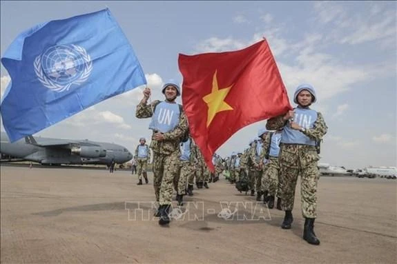 Các bác sĩ quân y Việt Nam giương cao hai lá cờ của Liên hợp quốc và Việt Nam tại sân bay quốc tế Juba, bắt đầu thực hiện nhiệm vụ gìn giữ hòa bình Liên hợp quốc tại Nam Sudan. (Ảnh: TTXVN)