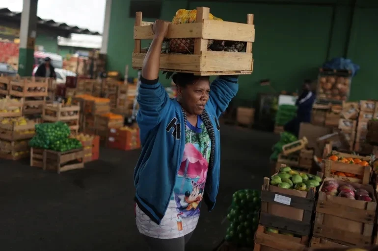 Người phụ nữ mang một hộp trái cây và rau quả do các thương gia quyên góp tại Trung tâm cung ứng CEASA ở Rio de Janeiro, Brazil, ngày 30/8/2022. (Ảnh: REUTERS)