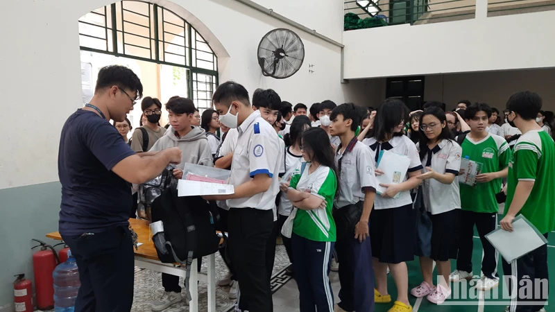 Các thí sinh làm thủ tục gửi đồ tại khu vực gửi đồ ở điểm thi Trường trung học phổ thông Lê Quý Đôn.
